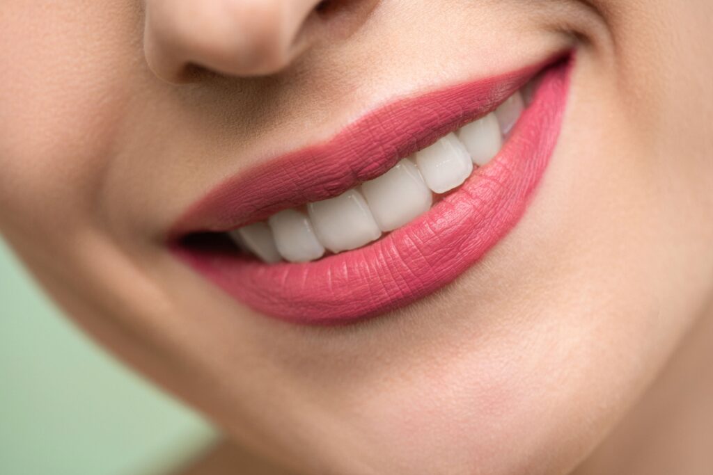 Nahaufnahme lächelnder Mund mit pinkem Lippenstift
